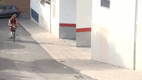 a woman riding a motorcycle down a narrow road