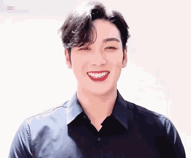 a young man wearing a black shirt is smiling for the camera