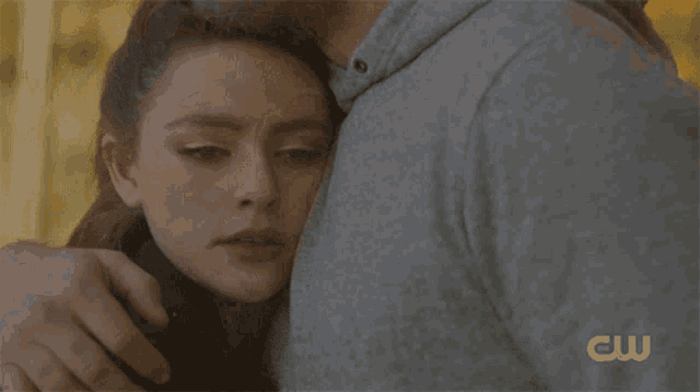 a close up of a woman hugging a man with the cw logo on the bottom