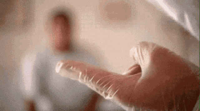 a close up of a person 's hand wearing a glove with a blurred background .