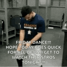 a man is dancing in a locker room while wearing a blue shirt and a hat .