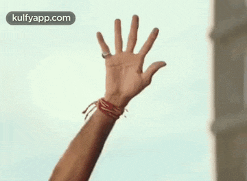 a close up of a person 's hand with a ring on it .