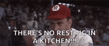 a baseball player in a red hat is sitting at a table .