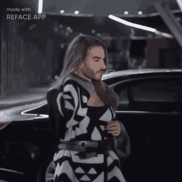 a man with long hair and a beard is standing in front of a car with the words made with reface app on the bottom