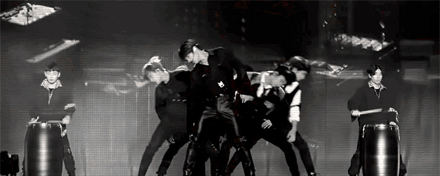 a black and white photo of a group of people standing on a stage .