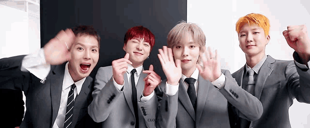 a group of young men wearing suits and ties are posing for a photo