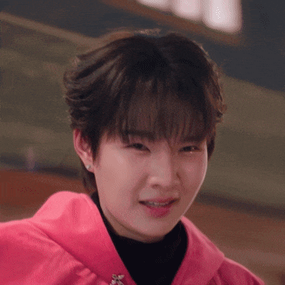a close up of a woman 's face wearing a pink jacket .