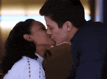 a man and a woman are kissing each other .