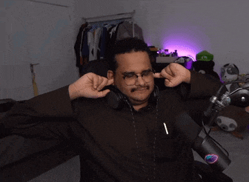a man wearing headphones and glasses is covering his ears