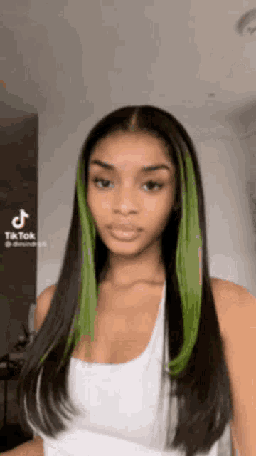 a woman with long black hair and green streaks .