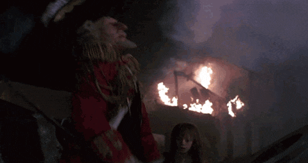 a person is standing in a dark room with a large explosion coming out of the ceiling .