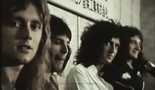a group of men are sitting next to each other in front of microphones .