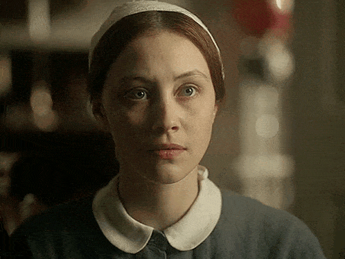 a close up of a woman wearing a headband and a collared shirt
