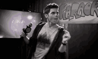 a man singing into a microphone in front of a karaoke sign