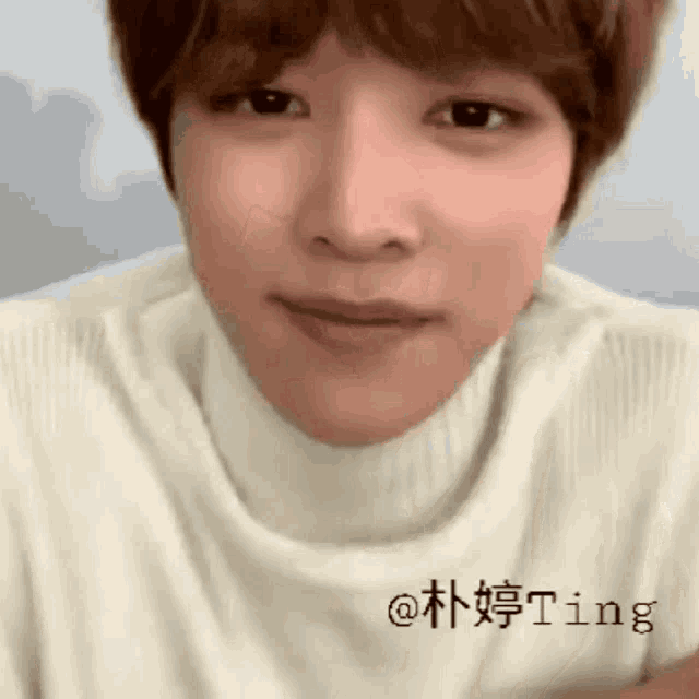 a close up of a person 's face wearing a white turtleneck .