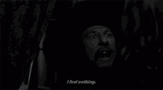 a man with a beard says i feel nothing in a black and white photo