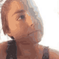 a close up of a woman 's face with the sun shining through her hair .