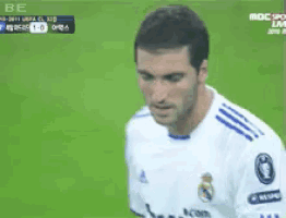 a soccer player wearing a white jersey with a blue stripe on the sleeves