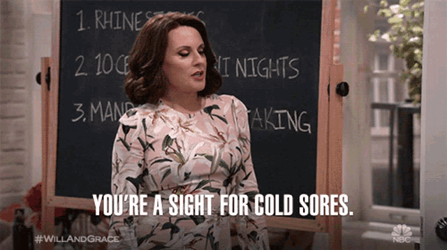 a woman standing in front of a blackboard that says you 're a sight for cold sores