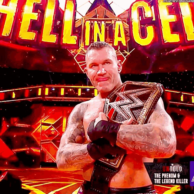 a wrestler is holding a wrestling belt in front of a sign that says hell in a cell