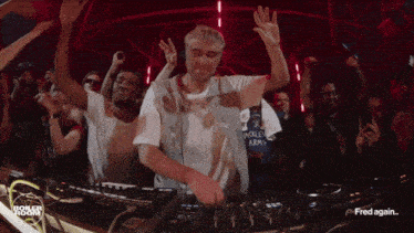a dj is playing music in front of a crowd and the words fred again are on the bottom