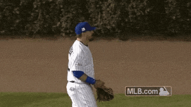 a baseball player is walking on the field with mlb.com in the corner