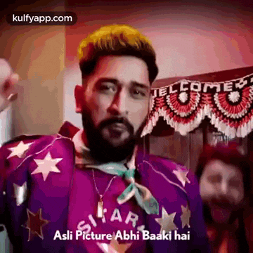 a man with a beard is wearing a purple jacket and necklace .