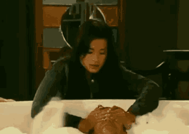 a woman is standing next to a man in a bathtub filled with foam .