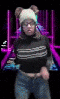 a woman wearing a white hat and glasses is dancing