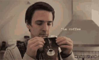 a man is holding a cup of coffee in his hands and drinking it .
