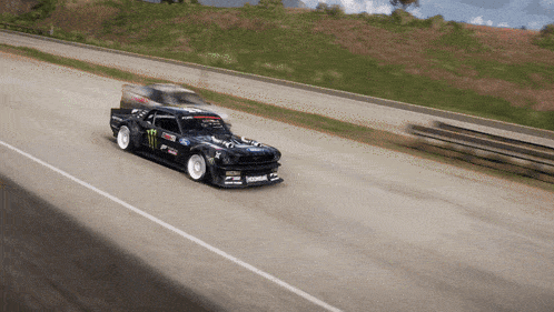 a monster energy car is driving on a road