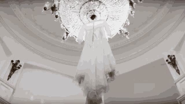 a white dress is hanging from a chandelier