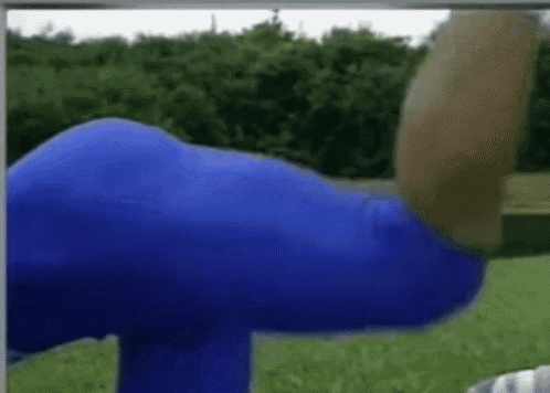 a person in blue pants is doing a yoga pose in a park .