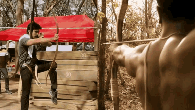 a man with a bow and arrow is aiming at a target with the number 12 on it