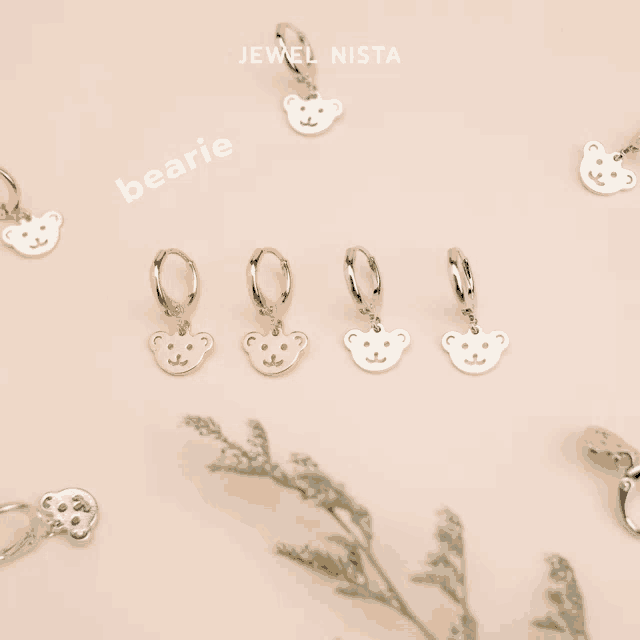 jewel nista bearie earrings are displayed on a pink background