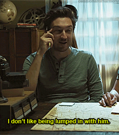 a man sitting at a table talking on a cell phone with the caption i don t like being lumped in