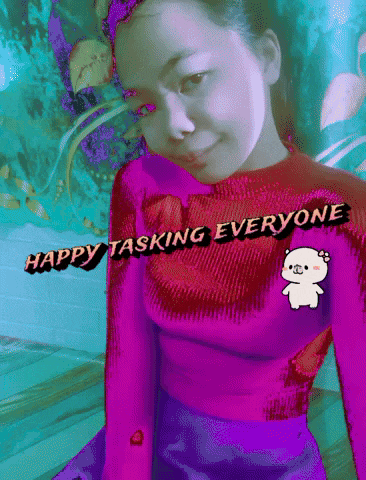 a woman in a pink sweater with the words happy tasking everyone written on it