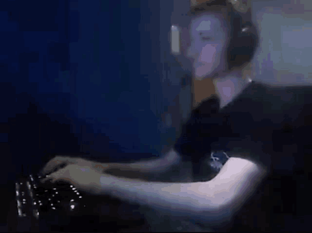 a man wearing headphones is sitting in front of a computer keyboard .