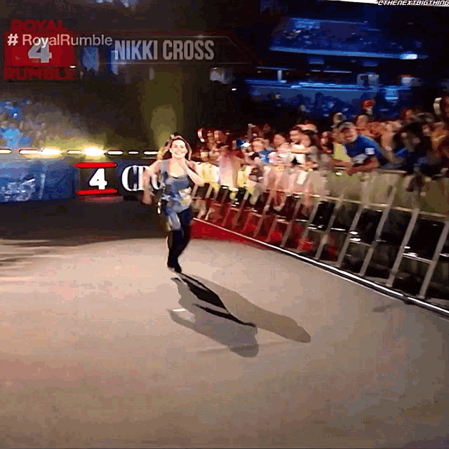 a woman is running in front of a sign that says royal rumble on it