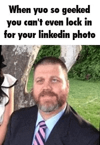 a man in a suit and tie is looking at the camera .