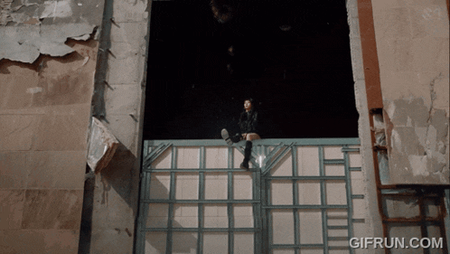 a gif from gifrun.com shows a person sitting on a fence