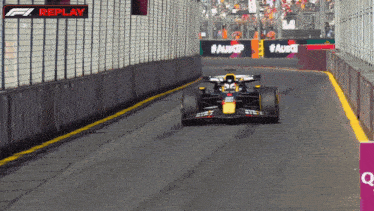 a race car is driving down a track with a sign that says replay