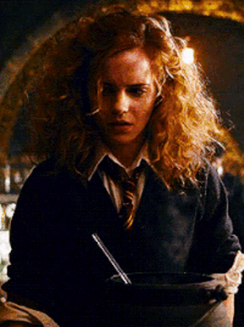 a woman with red hair is holding a cauldron with a straw in it