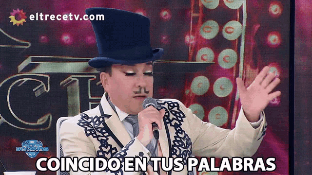 a man singing into a microphone with the words coincido en tus palabras on the bottom