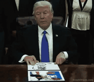 a man in a suit and tie is holding a book that says donald draws.com on it