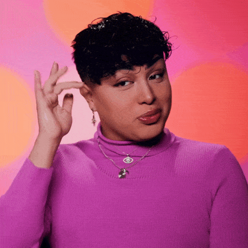 a woman wearing a purple turtleneck necklace and earrings is making a face