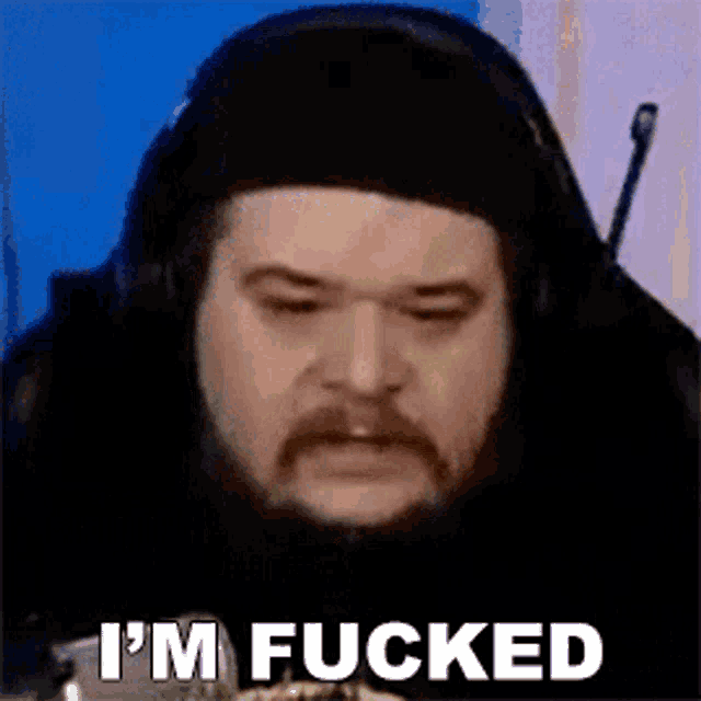 a man with a beard and mustache is wearing headphones and making a funny face .