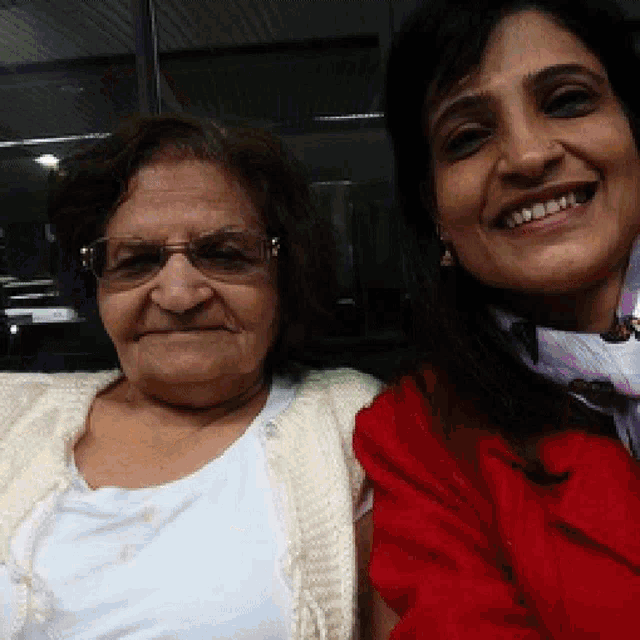 two women are posing for a picture together and smiling for the camera