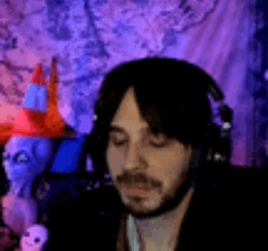 a man with a beard wearing headphones is sitting in front of a purple background .