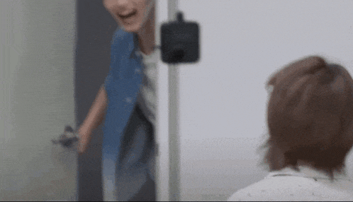 a man in a blue shirt is standing next to a woman in a white shirt in a room .
